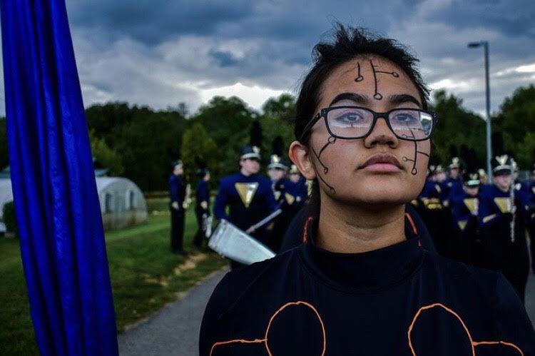Junior Hailey Irvin marching with the guard as the marching band enters the field. 
Photo courtesy of Esa Mayo-Pitts  