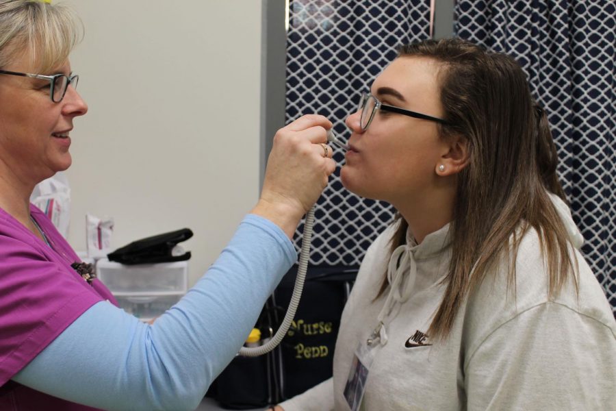 Nurse Penn checking sophomore Angelica Carters temperature. Photo courtesy of FCHS Journalism.
