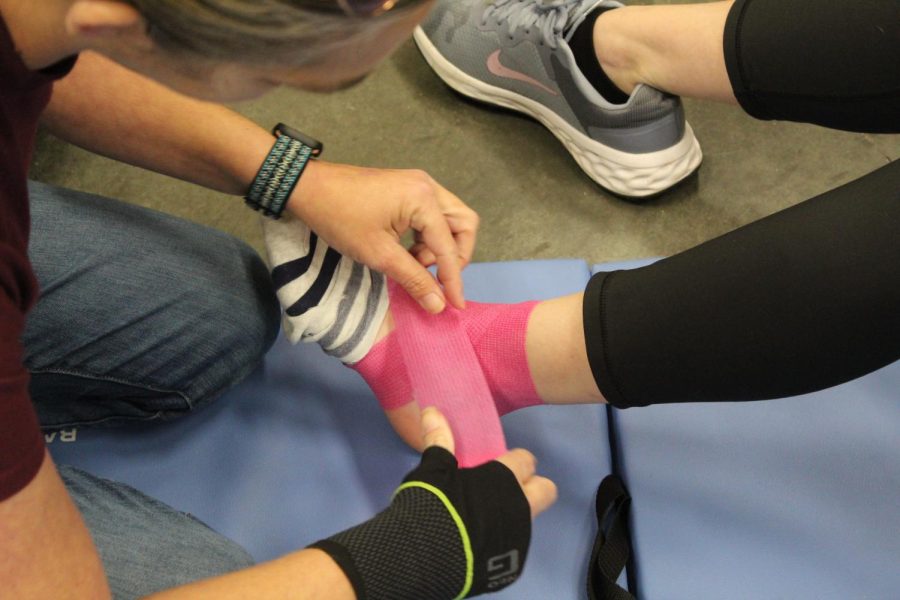 A student practices wrapping an ankle injury in Sharon Paynes EMT class.