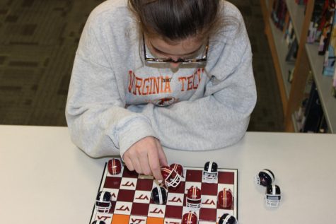 A student plays chess in the 4th floor Media Center. 