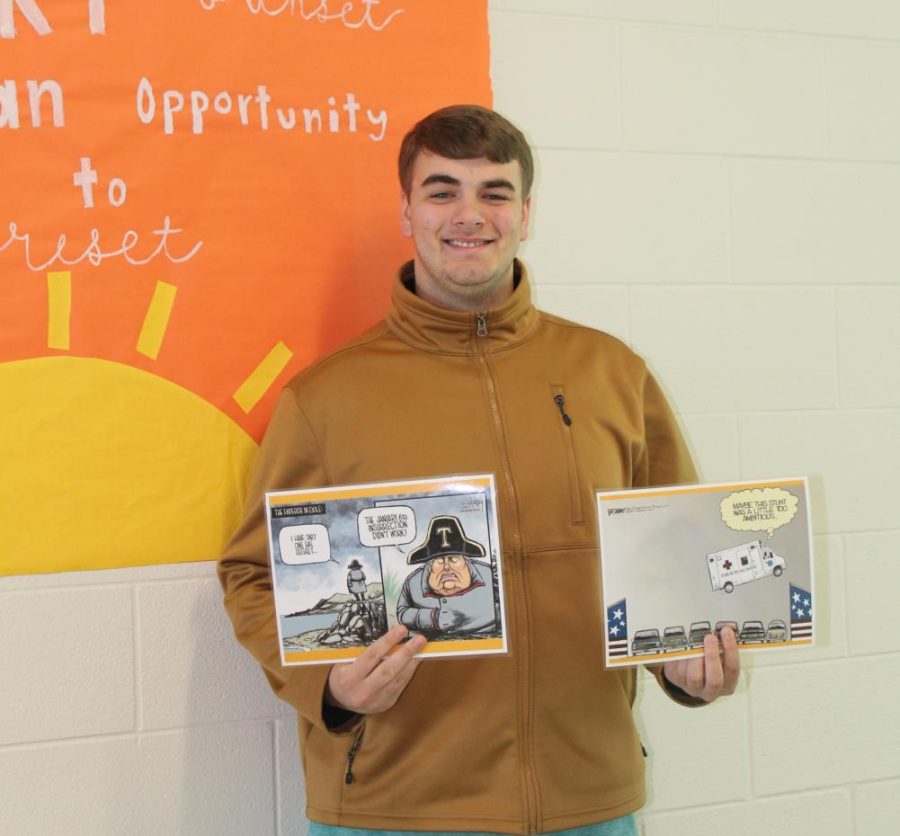 Senior Aden Melton, shows off two of the political cartoons that he used for his project in AP government. 