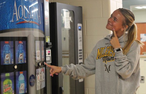 Sophomore River McMillian deciding to buy a drink from the vending machine.