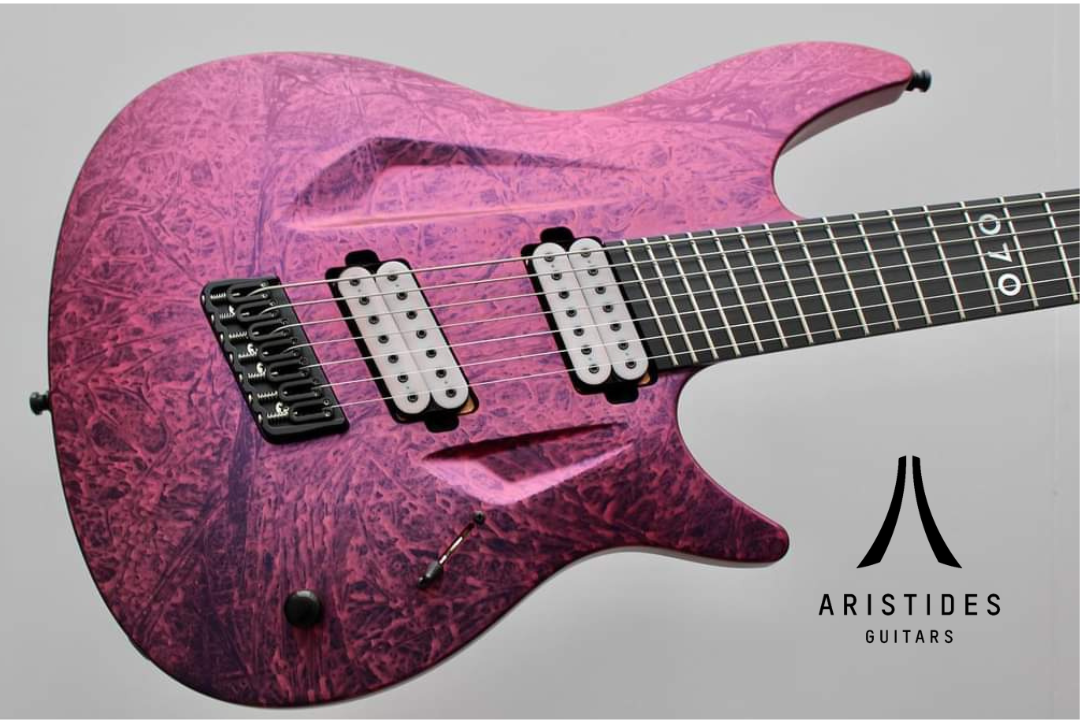 Photo of a pink and purple Aristides Guitar. Photo Courtesy of Aristides Guitars https://www.facebook.com/share/p/zgiGvhdH13iAki4N/?mibextid=qi2Omg. 

Logo added to image by Ethan Ritchey. Logo courtesy of Aristides Instruments https://aristidesinstruments.com/how-to-order.