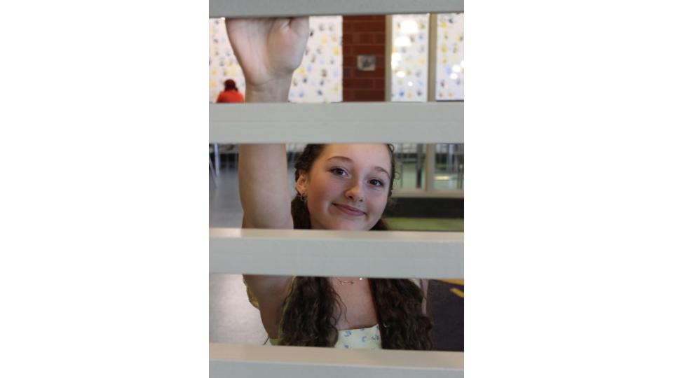 Emily Graves, framed by the railings in the cafeteria. Photo courtesy of Sophia Branch. 