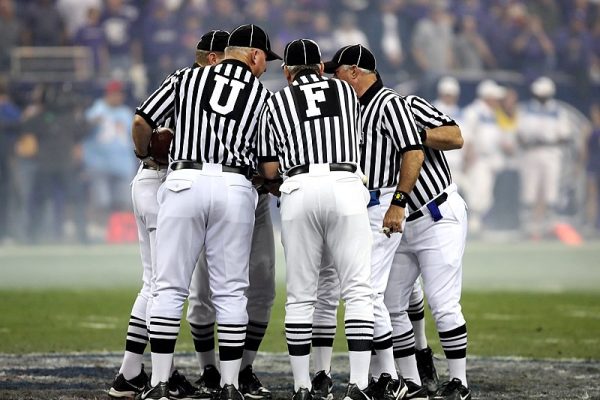 College football referees discussing a call at the Texas Bowl in Houston, Texas, December 28, 2006. Photo courtesy of Keith JJ under the Creative Commons CC0 1.0 Universal Public Domain Dedication. https://pixabay.com/photos/american-football-1464551/