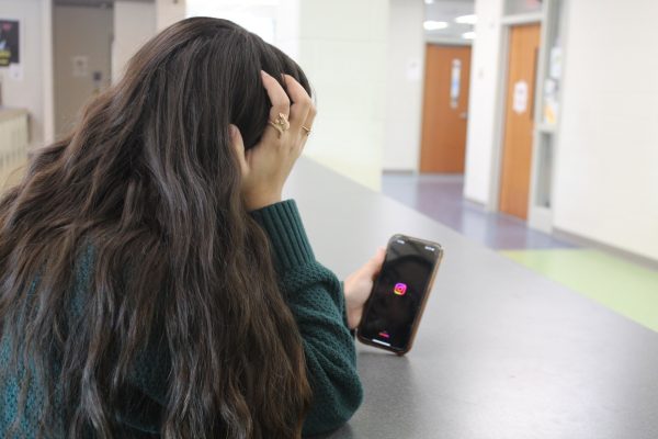 FCHS student looks at her phone stressed.