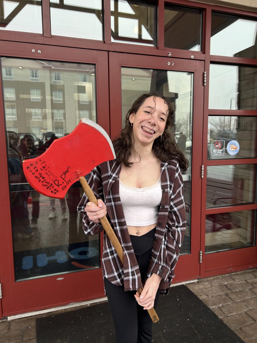 Junior Kaylee Beirne with the Lumberjack Friday ax after winning the syrup chugging contest.