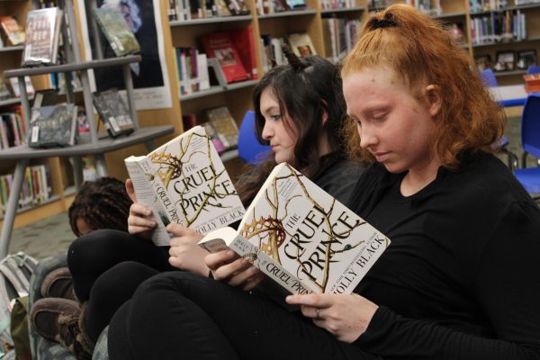 Sophomores Lila Mathews and Maya Blackburn read The Cruel Prince in the FCHS Media Center on Read Across America Day, March 7. Photo courtesy of Fluco Journalism.