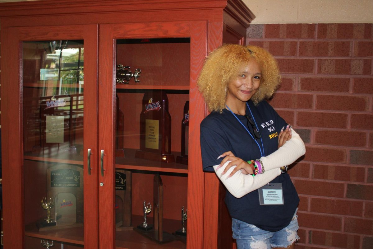 Natalie Fanning '26 posing next to the forensics award case.