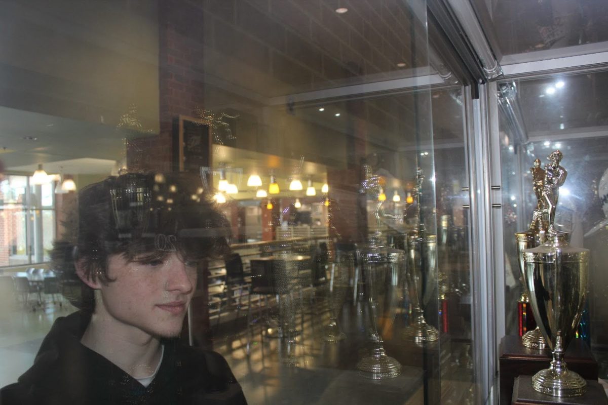 Junior Cassidy Relyea looks at the FCHS trophies in the Cafeteria.