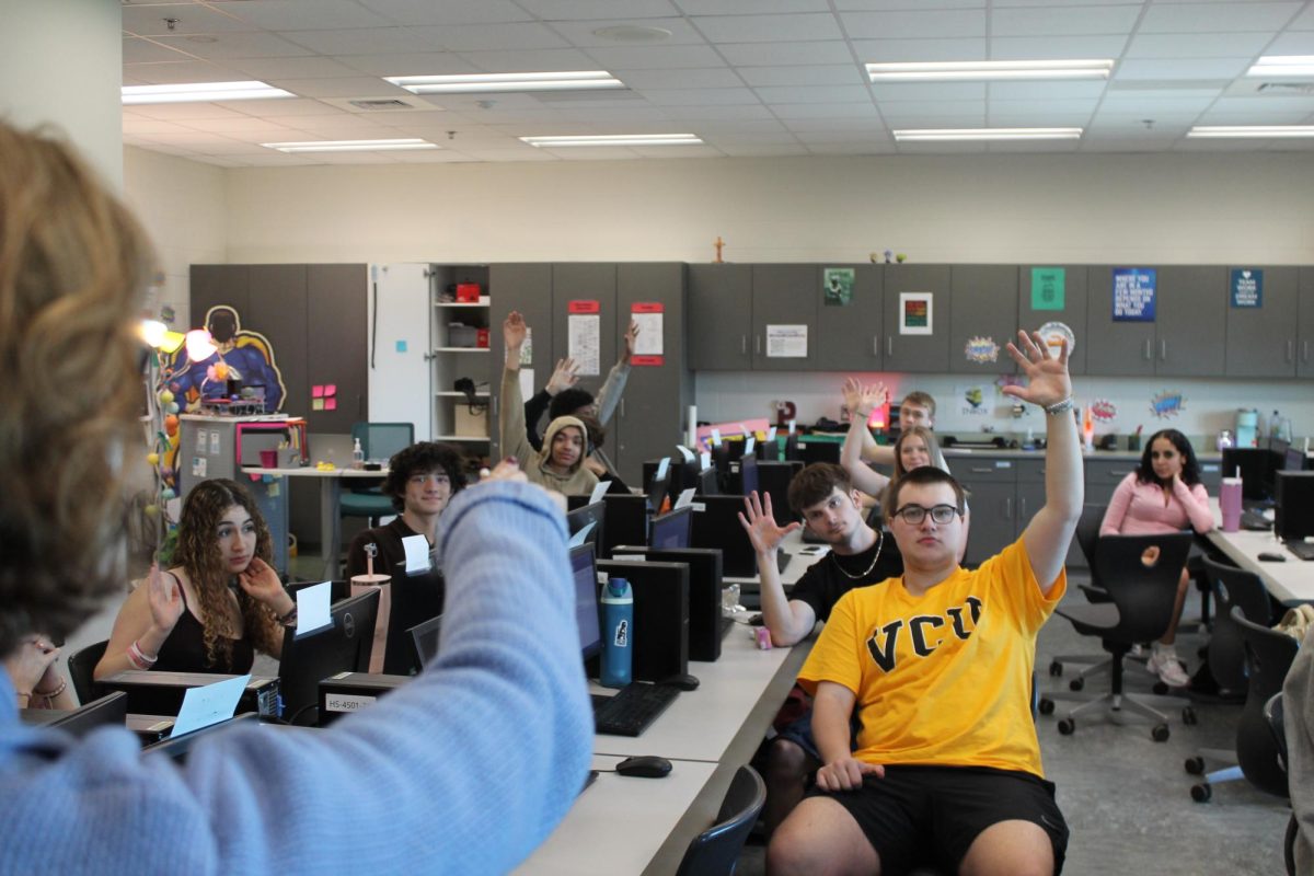 Image of Mrs Pellicane calling on students with their hands raised.