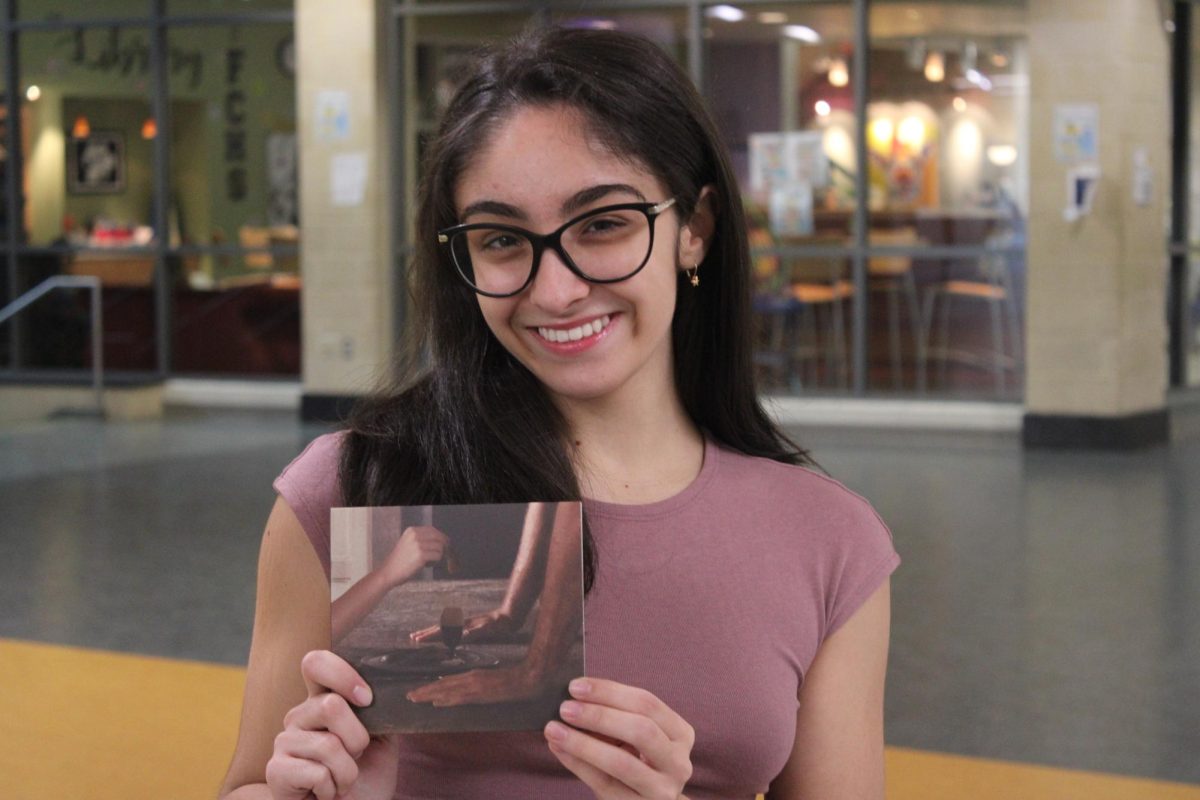 Senior Victoria ScottoDiVetta holding up the Wuthering Heights CD by singer Charli XCX 