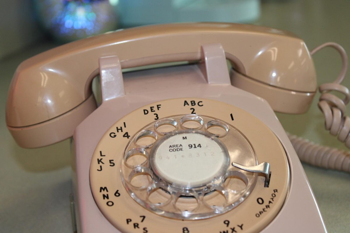 Close-up of a pink rotary phone.