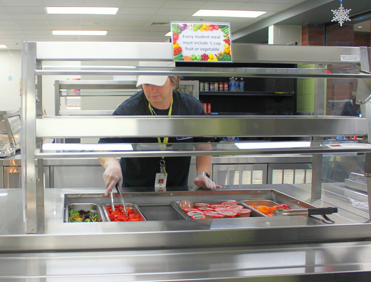 One of the lunch ladies sets up food before lunch in the FCHS cafeteria.