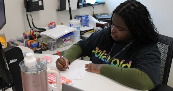 Danna Djinigou grades a work sheet from a student.