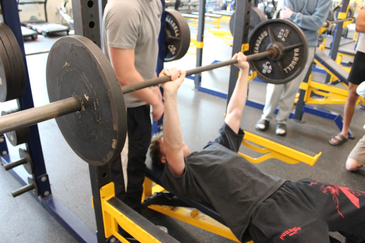 Junior Jackson Evans benches in the FCHS weight room.